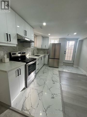 Niagara Falls (Brown) apartment for rent - A kitchen with white cabinets and marble countertops.