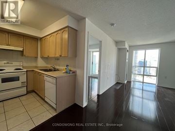 Toronto (Willowdale East) condo for rent - A kitchen with wooden cabinets and a white stove top oven.