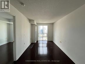 Toronto (Willowdale East) condo for rent - A long hallway with a door on the left and a window on the right.