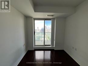 Toronto (Willowdale East) condo for rent - Empty room with a large window overlooking a cityscape.
