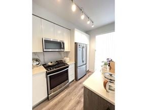 Surrey townhouse for rent - A kitchen with a stove, microwave, and refrigerator.