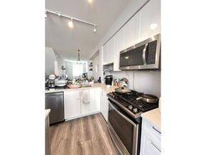 Surrey townhouse for rent - A kitchen with a stove top oven and microwave.
