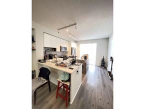 Surrey townhouse for rent - A kitchen with a table and chairs in the foreground and a guitar leaning against the wall in the background.