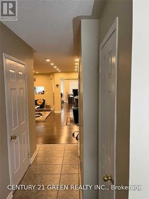 Milton (De Dempsey) apartment for rent - A hallway with a door on the left and a kitchen area in the distance.