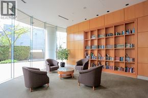 Vancouver apartment for rent - A room with a glass wall and a bookshelf filled with books.