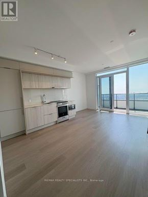 Mississauga (City Centre) condo for rent - A spacious kitchen with wooden flooring and a large window overlooking the ocean.