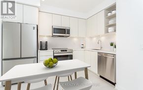 Mississauga (Central Erin Mills) house for rent - A modern kitchen with a white table and chairs, a refrigerator, a microwave, and a stove.