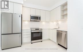 Mississauga (Central Erin Mills) house for rent - A white kitchen with a refrigerator, microwave, oven, and dishwasher.