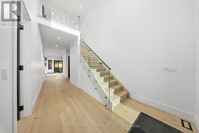 Mississauga (Mineola) apartment for rent - A hallway with a staircase and a black doormat.