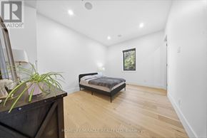 Mississauga (Mineola) apartment for rent - A bedroom with a bed, wooden floors, and a painting on the wall.