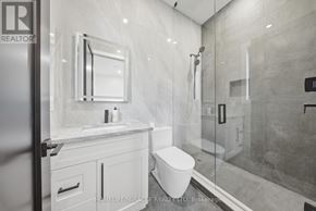Mississauga (Mineola) apartment for rent - A modern bathroom with a glass shower stall and a white toilet.