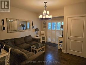 Barrie (Holly) condo for rent - A living room with a grey couch and a chandelier.