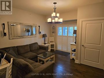 Barrie (Holly) condo for rent - A living room with a grey couch and a chandelier.