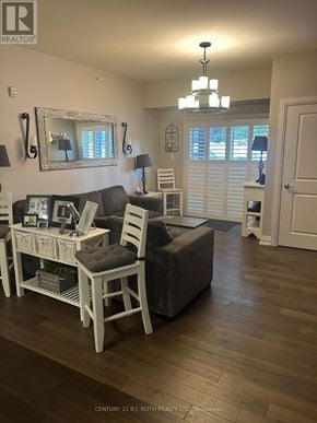 Barrie (Holly) condo for rent - A living room with a grey couch and a white chair.