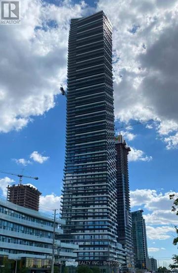 Mississauga (City Centre) condo for rent - A tall building under construction with a crane on the left side.
