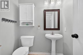 Ottawa apartment for rent - A white toilet sits next to a white pedestal sink in a small bathroom.
