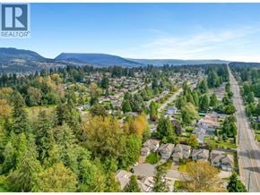 Coquitlam apartment for rent - A realtor logo is on a picture of a suburban neighborhood.