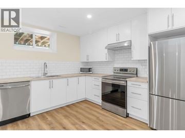 Coquitlam apartment for rent - A modern kitchen with white cabinets and stainless steel appliances.