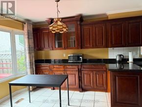 Markham (Raymerville) apartment for rent - A kitchen with brown cabinets and a black table.