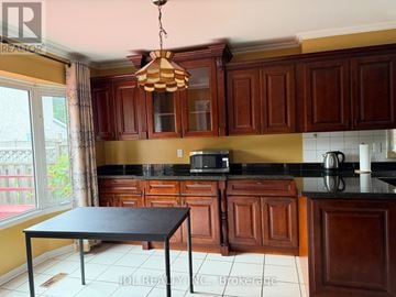 Markham (Raymerville) apartment for rent - A kitchen with brown cabinets and a black table.