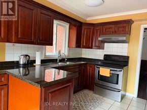 Markham (Raymerville) apartment for rent - A kitchen with wooden cabinets and a black countertop.