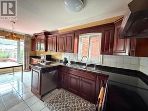Markham (Raymerville) apartment for rent - A kitchen with dark wood cabinets and a black counter top.