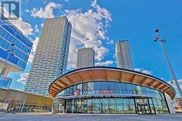 Vaughan (Vaughan Corporate Centre) condo for rent - A modern building with a curved glass facade and a sign that reads "SMARTVAC".