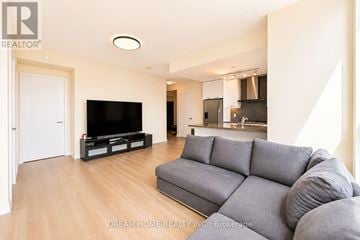 Toronto (Waterfront Communities) condo for rent - A modern living room with a grey sofa and a flat screen TV.