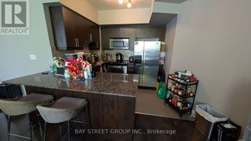 Toronto (Willowdale East) townhouse for rent - A kitchen with granite countertops and a bar area with stools.