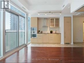 Toronto (Waterfront Communities) condo for rent - A kitchen with wooden floors and a large island with a sink.