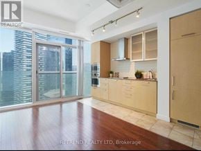 Toronto (Waterfront Communities) condo for rent - A modern kitchen with wooden floors and cabinets.