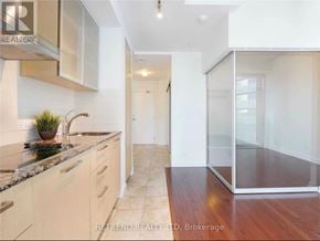 Toronto (Waterfront Communities) condo for rent - A kitchen with a marble countertop and wooden flooring.