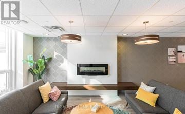 Barrie (City Centre) condo for rent - A living room with a grey couch and a wooden coffee table.