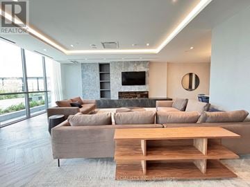 Milton (Tm Timberlea) condo for rent - A modern living room with a large couch and a fireplace.