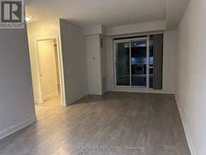 Toronto (Mimico) condo for rent - A room with a sliding glass door and wooden flooring.