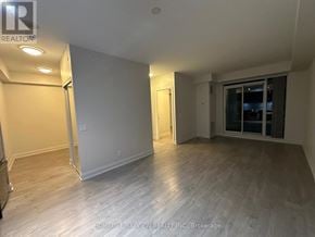Toronto (Mimico) condo for rent - A spacious room with wooden flooring and white walls.