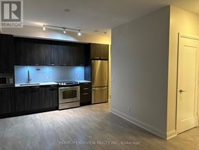 Toronto (Mimico) condo for rent - A kitchen with dark wood cabinets and stainless steel appliances.