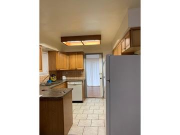 Surrey apartment for rent - A kitchen with a refrigerator, sink, and cabinets.
