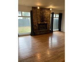 Surrey apartment for rent - A room with a fireplace and wooden floors.