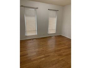 Surrey apartment for rent - A room with wooden flooring and two windows with blinds.