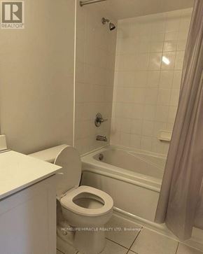 Mississauga (City Centre) condo for rent - A white toilet is in a bathroom with a shower.