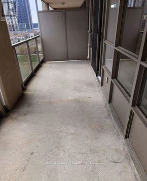 Mississauga (City Centre) condo for rent - A view of a balcony with a closed door and a glass railing.