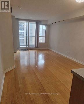 Mississauga (City Centre) condo for rent - A room with wooden flooring and a large window.