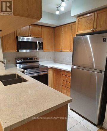 Mississauga (City Centre) condo for rent - A kitchen with wooden cabinets and a stainless steel refrigerator.
