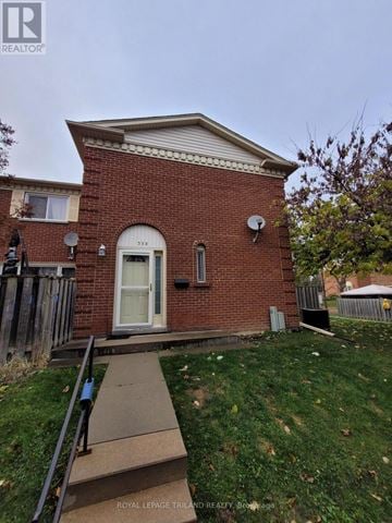 London North (North F) townhouse for rent - A small red brick house with a white door and a satellite dish on the roof.