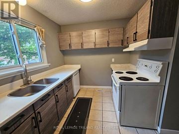 London North (North F) townhouse for rent - A kitchen with a white stove and brown cabinets.