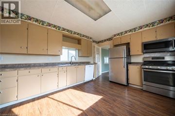 Brantford other for rent - A kitchen with wooden floors and a wallpapered ceiling.