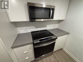 Toronto (Clanton Park) condo for rent - A modern kitchen with a stainless steel oven and microwave above it.