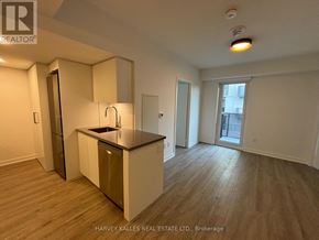 Toronto (Clanton Park) condo for rent - A kitchen with a sink and a refrigerator in a room with wood flooring.