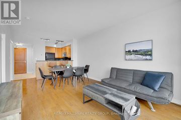 Ottawa condo for rent - A living room with a grey couch, a dining table with chairs, and a painting on the wall.
